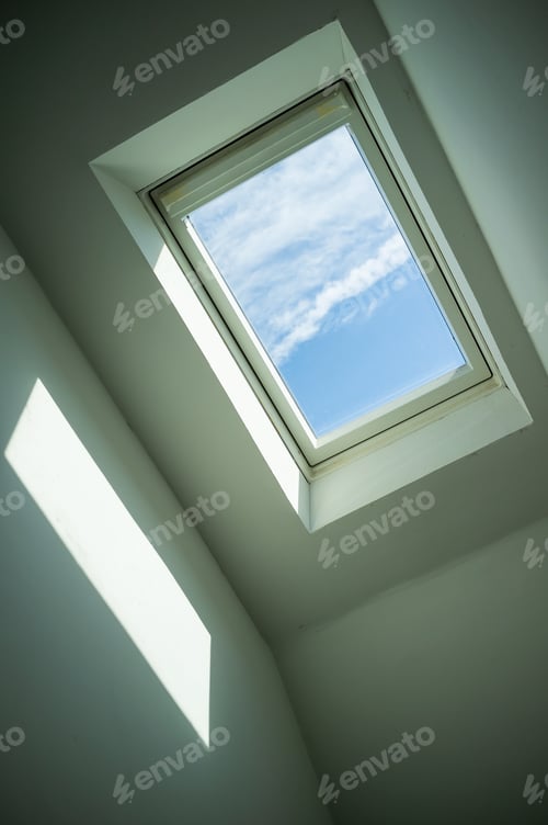 Preview: Closed roof window through which you can see the blue sky and white clouds on sunny day. Bottom view