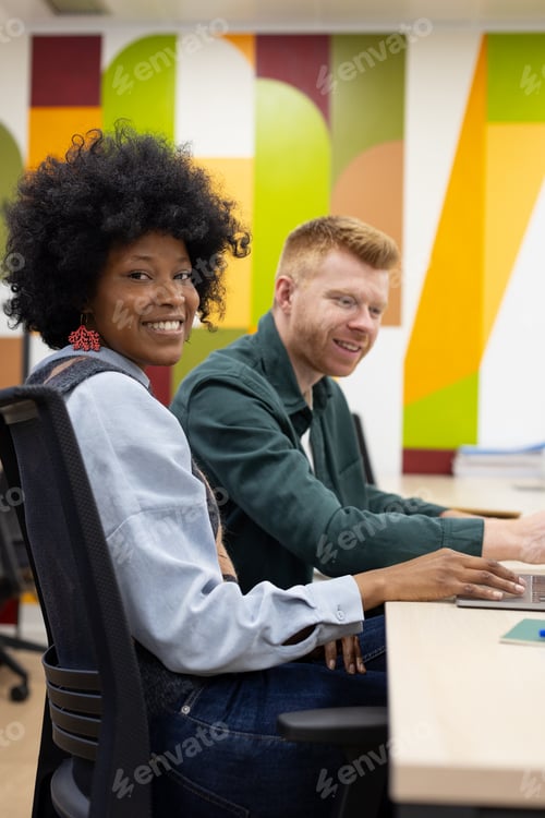 Preview: Diverse colleagues smiling and collaborating in modern office