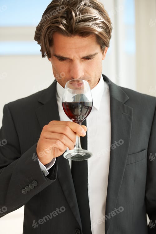 Preview: Fruity yet playful. A handsome wine connoisseur enjoying a glass of red wine.