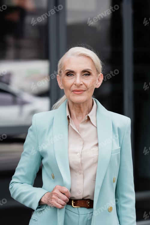 Preview: Senior businesswoman in formal wear looking at camera outdoors