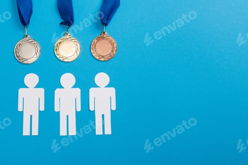 Preview: top view of white paper cut people near silver and golden medals on blue