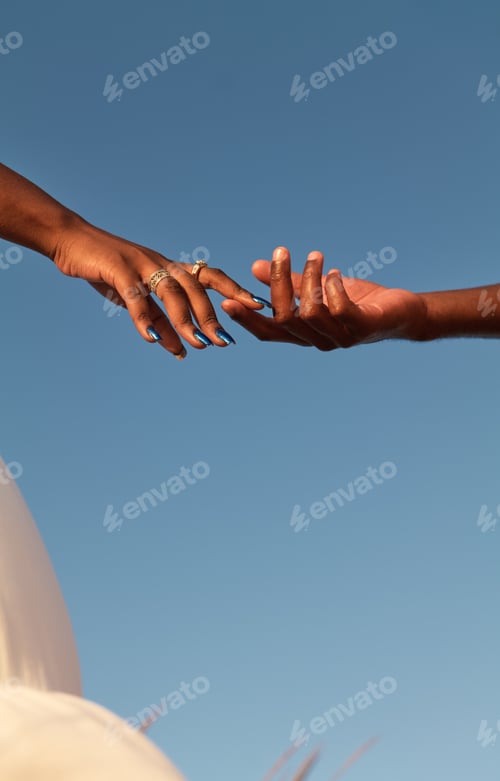 Preview: Crop black couple touching fingers in sunlight