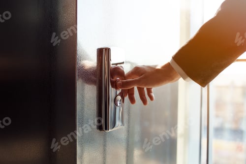 Preview: Man pressing elevator button. finger presses the elevator button. Red button. sunset light.