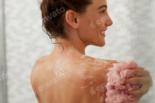 Preview: Beautiful woman showering with pink body puff