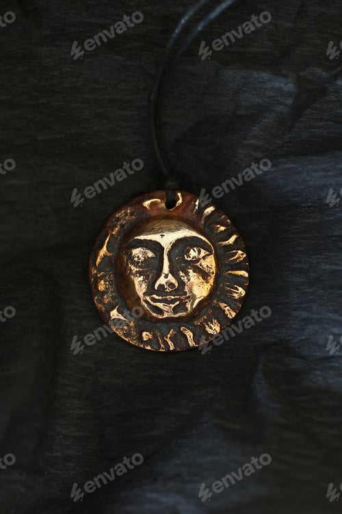 Preview: Bronze Pendant with Ancient Sun Face on Black Background, Mystical Jewelry and Celestial Symbolism.
