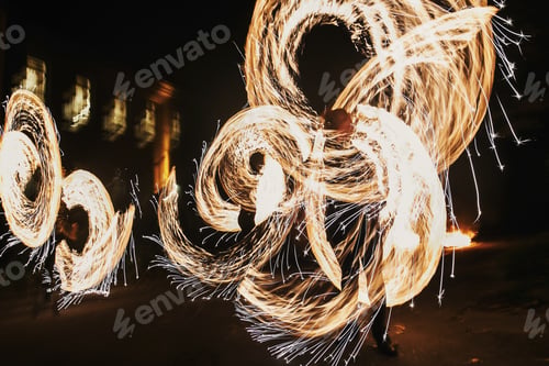 Preview: Fire dancers swing, spinning fire and man juggling with bright sparks in the night