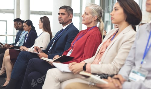 Preview: Diverse business people looking serious while attending a business seminar in office building