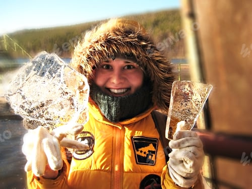 Preview: Winter fun - Happy girl in hood and yellow jacket with ice plates