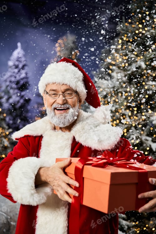 Preview: Joyful Santa Claus in a snowy wonderland holding a gift box amid festive holiday decorations