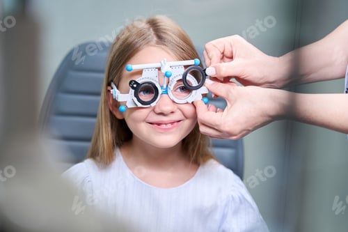 Preview: Qualified ophthalmologist performing subjective refraction test on child