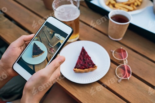 Preview: Hands of young female with smartphone taking photo of tasty cake