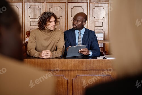 Preview: Young confident male attorney pointing at document while explaining information