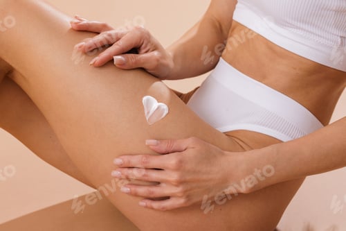 Preview: Woman spreads heart-shaped lotion on leg. Skincare and beauty wellness.