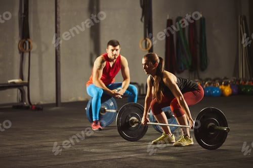 Preview: Woman squatting and lifting a barbell.