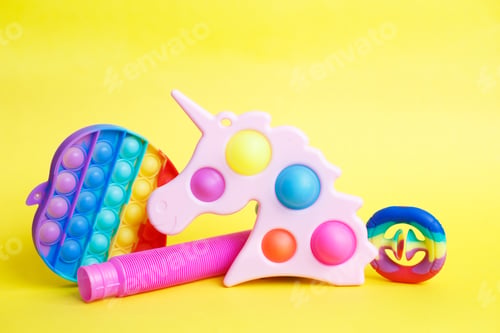 Preview: colorful antistress sensory fidget toys on a yellow background