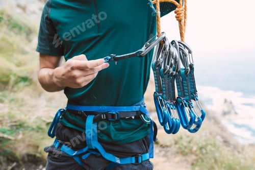 Preview: Young man preparing climbing equipment