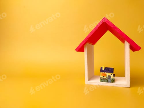 Preview: Toy house and miniature house isolated on yellow background with copy space