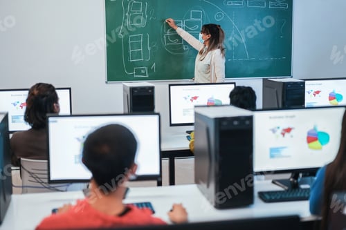 Preview: Multiracial students using computers during business class wearing safety masks at school