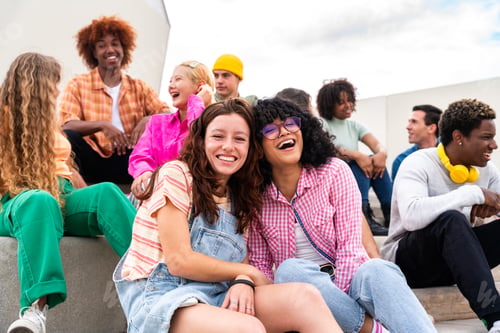 Preview: Happy playful multiethnic group of young friends bonding outdoors