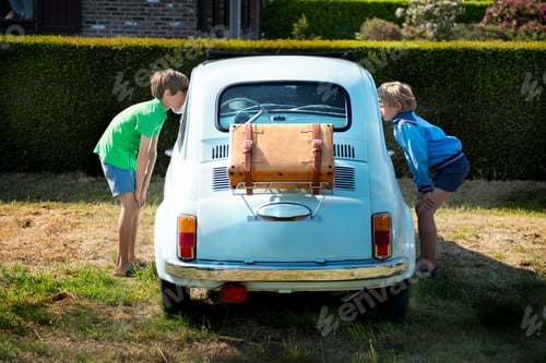 Preview: Boys looking through windows of vintage automobile