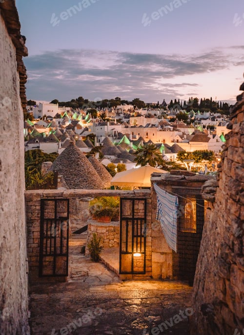 Preview: View of the Trulli of Alberobello at sunset with city lights