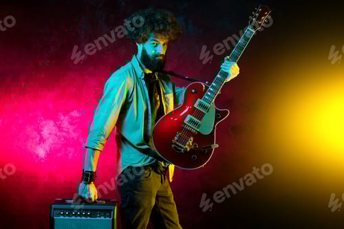 Preview: Man with Guitar Performing Under Colorful Stage Lights