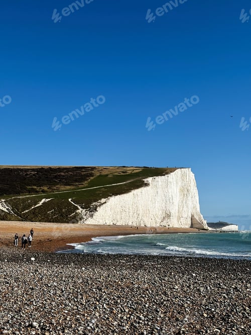 Preview: Hikers along the Seven Sisters Cliffs in East Sussex England with white chalk cliffs