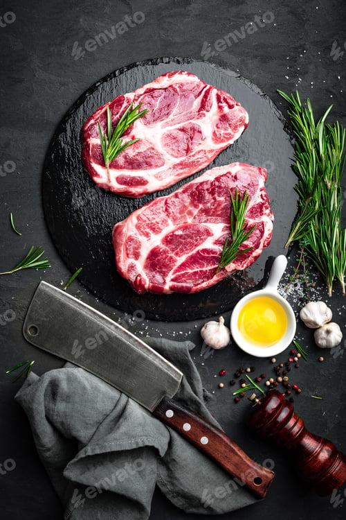 Preview: Cooking on kitchen table fresh raw pork marbled steaks on black background, top view