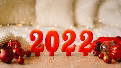 Visualização: Feliz Ano Novo 2022. Números do ano 2022 feitos por velas vermelhas no fundo cintilante festivo bokeh