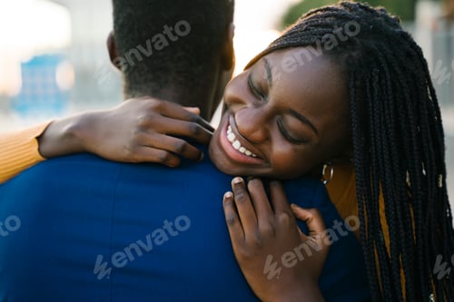 Preview: Young black woman hugging her boyfriend from behind, smiling