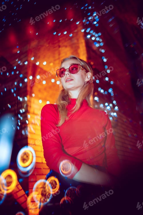 Preview: Cinematic portrait of handsome young woman in neon lighted room, stylish musician
