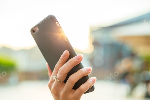 Preview: Woman holding cellphone at outdoor
