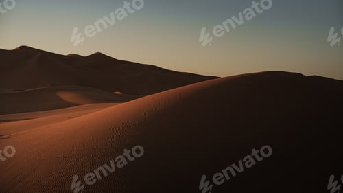 Preview: Warm sunlight illuminating the rolling sand dunes of erg chebbi, merzouga desert, morocco