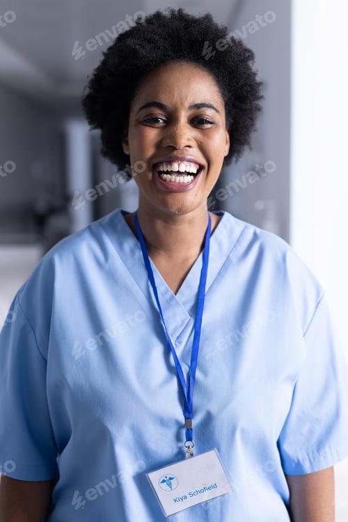 Preview: Portrait of happy african american female doctor in hospital corridor