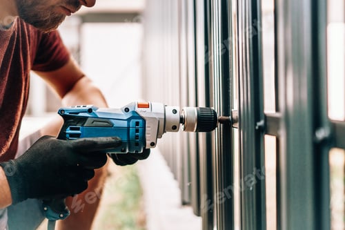 Preview: Man working with an electric screwdriver on the construction site