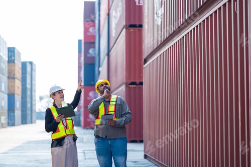 Preview: Warehouse engineer inspects merchandise with large customer at industrial container yard.