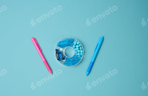 Preview: Set of stationery objects: pen, paper clip, buttons and clip on a blue background. View from above