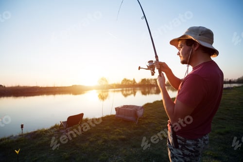 Preview: Young man fishing at pond and enjoying hobby