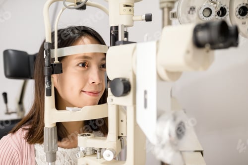Preview: Woman doing eye test in medical office