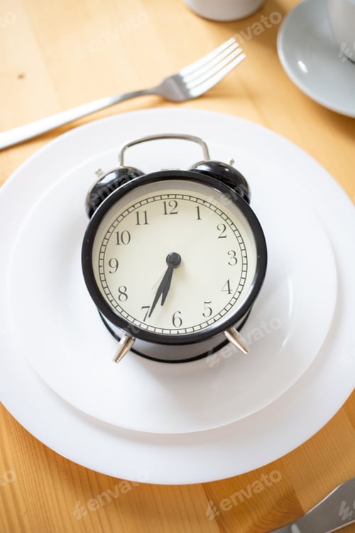 Preview: intermittent fasting concept alarm clock on kitchen table