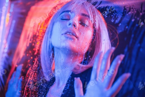 Preview: Eyes are closed. Stylish woman with white hair is behind wet transparent plastic sheet