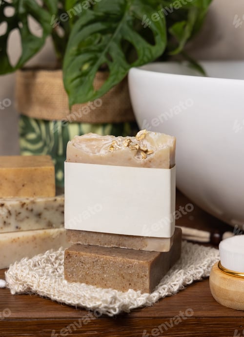 Preview: Soap bar with blank label on bath wooden countertop near monstera plant close up, mockup