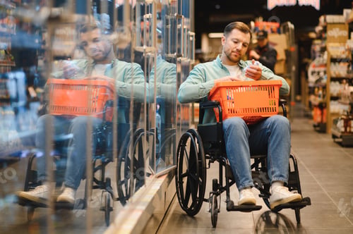 Preview: Customer with disability choosing products in supermarket using wheelchair