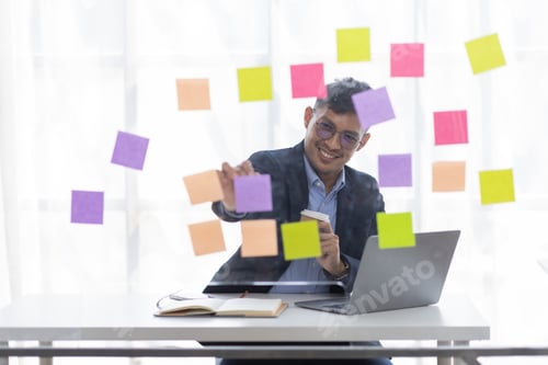 Preview: Concentrated adult business asian man, organizing his busy work week in the office. documents money