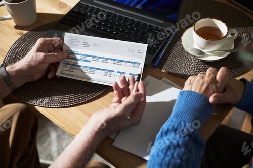 Preview: Senior Couple Holding Hands While Reviewing Utility Bills