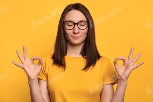 Preview: Young Woman Meditating Against Yellow Background