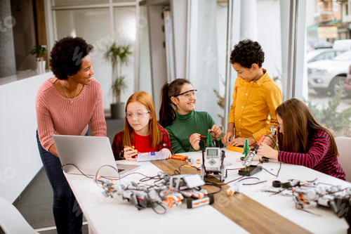 Preview: happy kids with their African American female science teacher with laptop