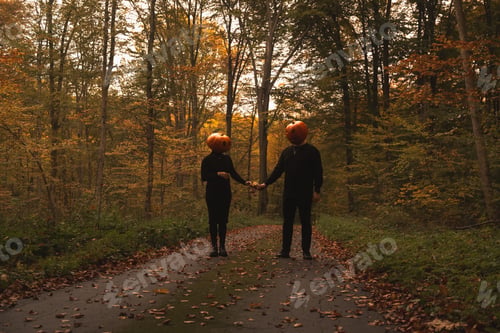 Preview: Couple in Pumpkin Heads Amidst Autumn Forest