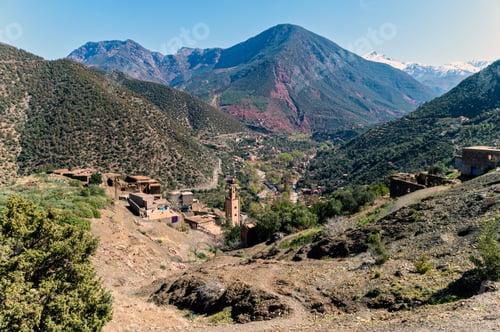 Preview: Majestic view of the Atlas Mountains showcasing traditional villages nestled in a lush valley.