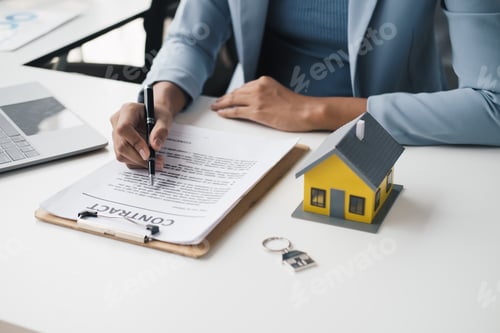 Preview: Close-up Of A Real Estate Agent's Hand Filling Contract Form Over Desk.